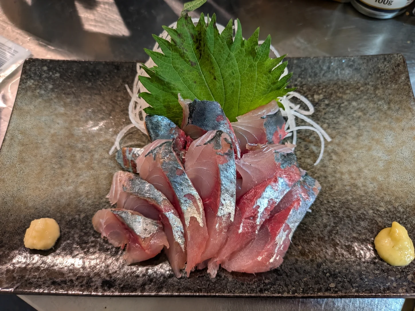 元漁師の店主が鮮魚を目利きする様子